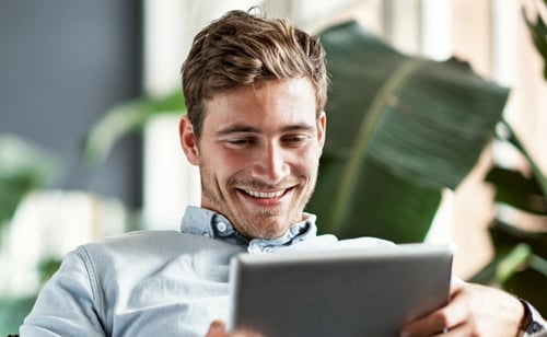 man smiling looking at ipad