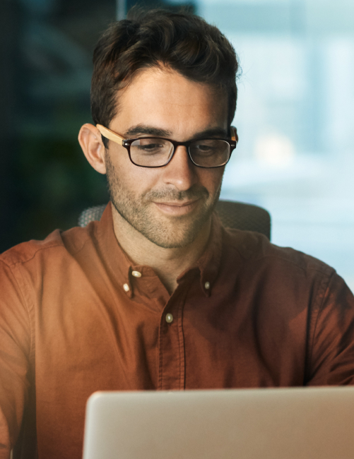 man using a laptop while working late in his office