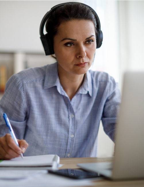 woman wearing headphones looking at her laptop