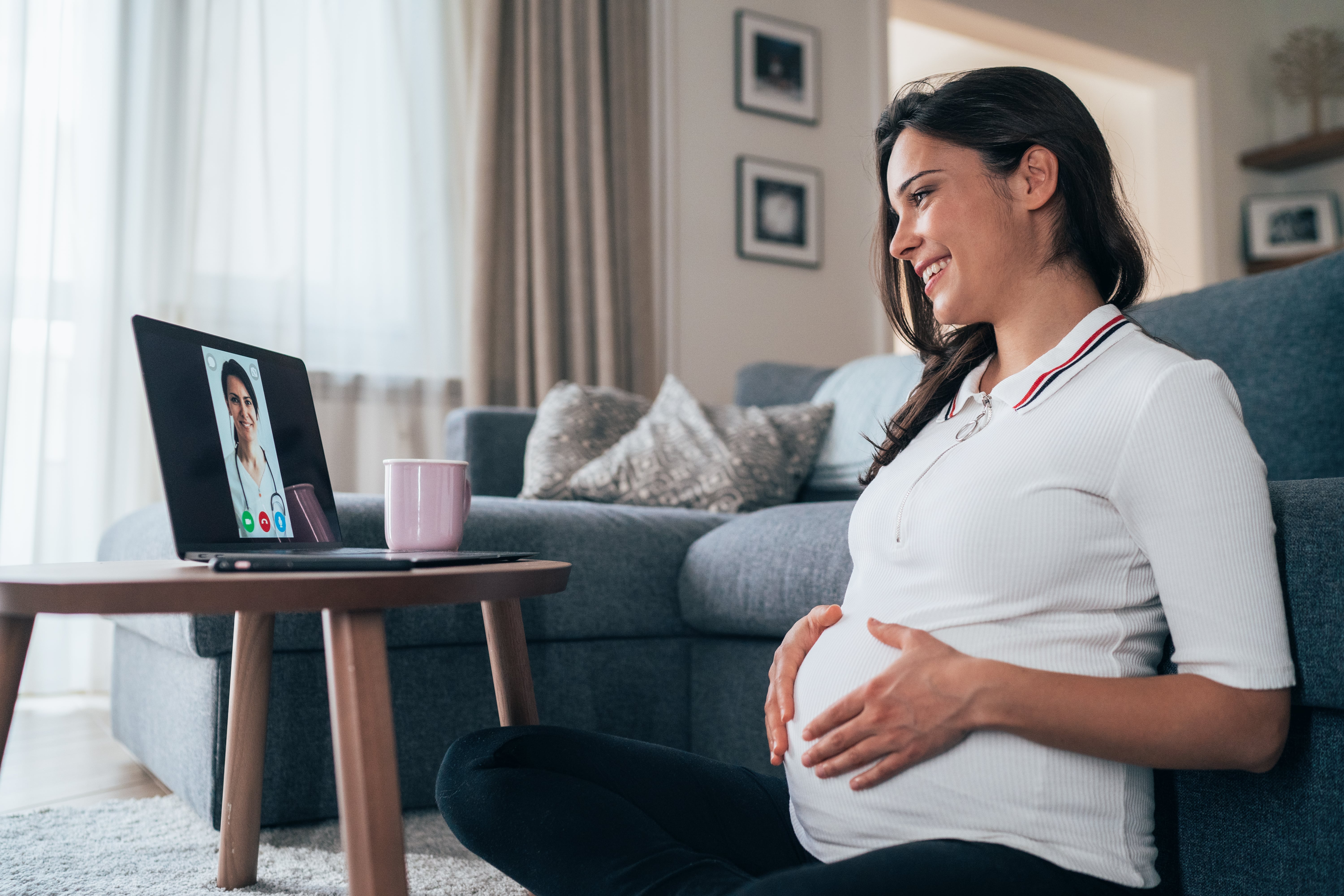 A pregnant women speaks with her doctor in a telehealth visit